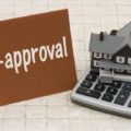 Sign showing the word preapproval with a home and calculator model to explain the process of being preapproved for purchasing a home.