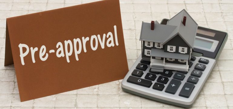 Sign showing the word preapproval with a home and calculator model to explain the process of being preapproved for purchasing a home.