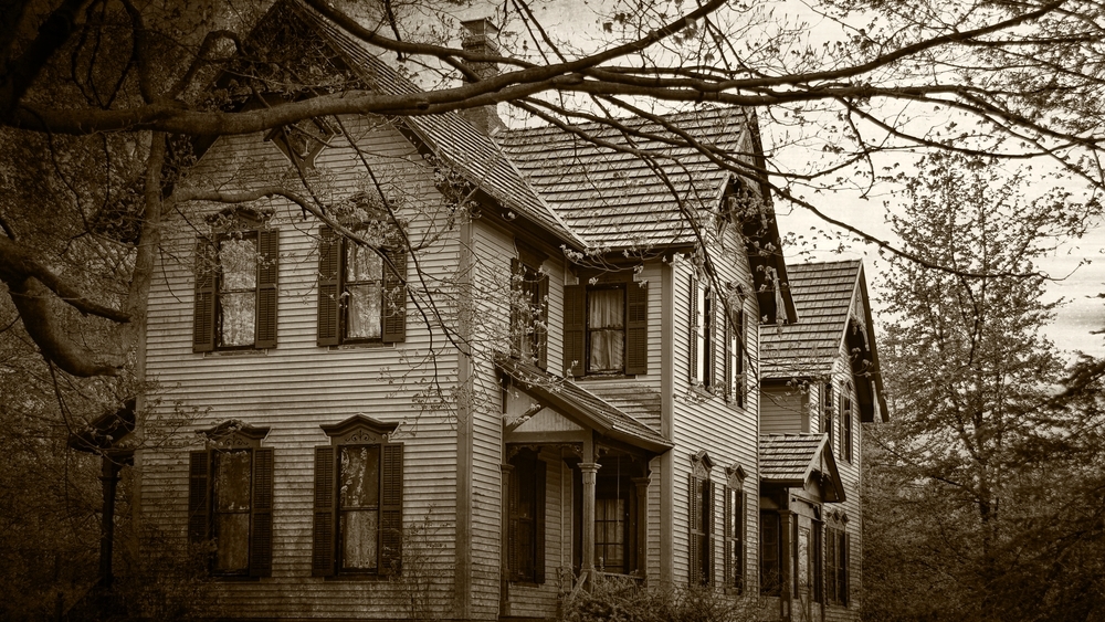 A black and white photo of an old haunted house.