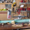 A home workshop of with many essential tools hanging in the background.
