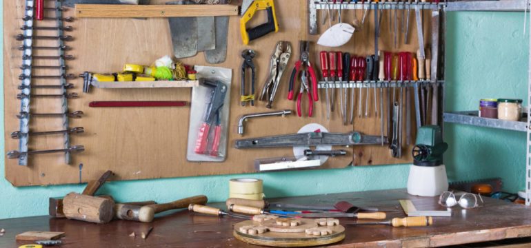 A home workshop of with many essential tools hanging in the background.