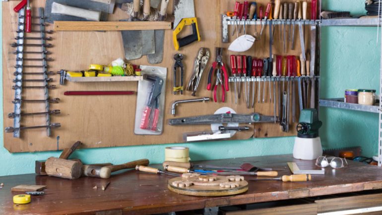 A home workshop of with many essential tools hanging in the background.