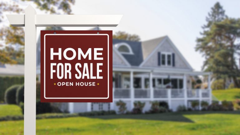 Home For Sale and Open House Real Estate Sign in front of a typical American style house.