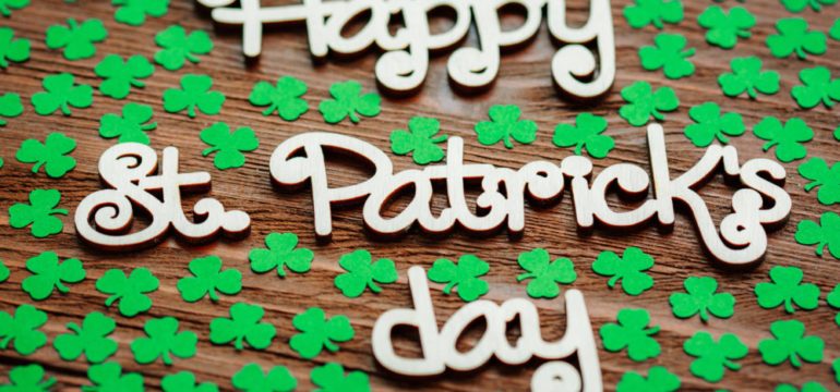 Happy St. Patrick's Day with shamrocks and wooden background