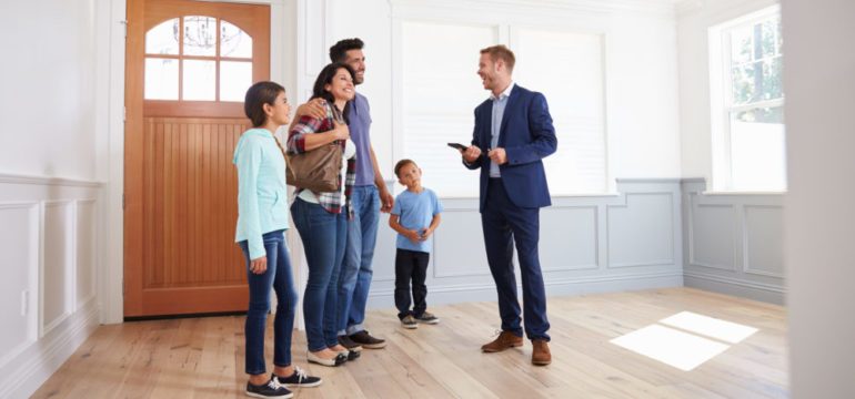 Relocation real estate agent showing family around a new home.