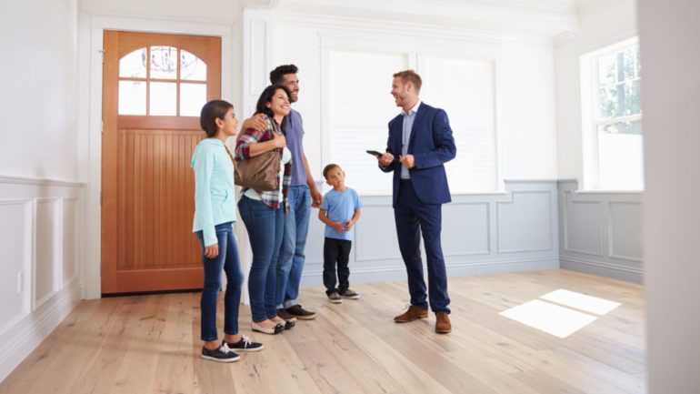 Relocation real estate agent showing family around a new home.