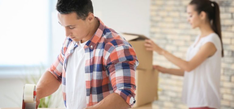 Young couple packing boxes at home while preparing for house move