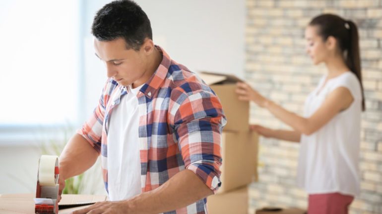 Young couple packing boxes at home while preparing for house move