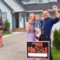 Selling your home takes teamwork. A young family celebrate selling a home working as a team with their real estate agent.