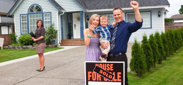 Selling your home takes teamwork. A young family celebrate selling a home working as a team with their real estate agent.