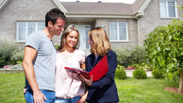 Real Estate agent woman near new house. Home for "Coming Soon" for sale concept.