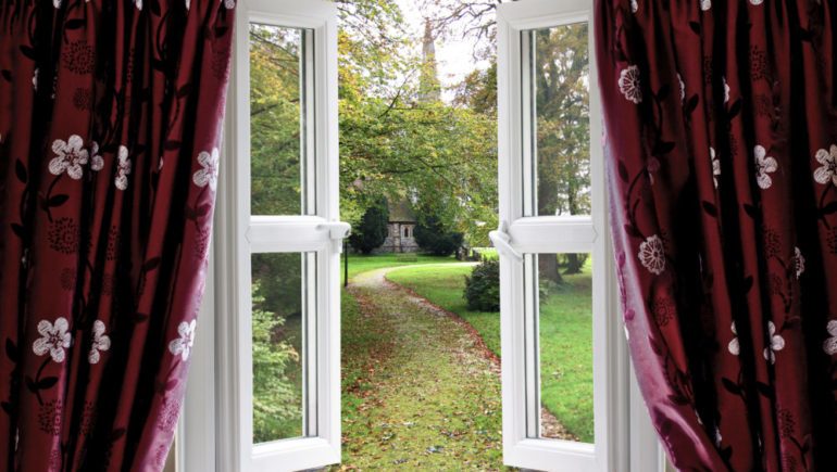 Open window looking out at a garden helps to lower energy bills in the summer.