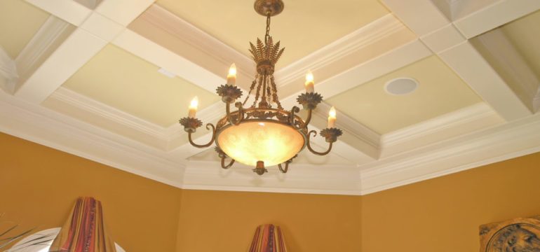 Luxury dining room with elegant coffered ceiling and light fixture.