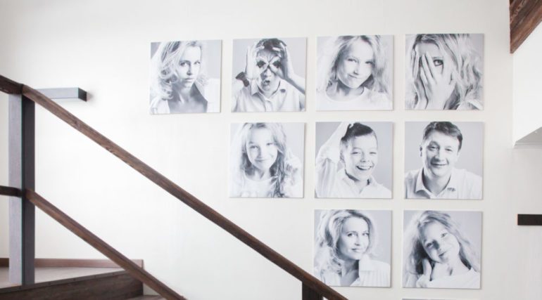 Family photos on hung on the stairwell wall in artistic display.