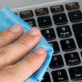 Close up holding blue wipes to clean your computer keyboard.