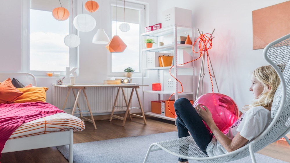 Teenage girl relaxing in her former kid's room.