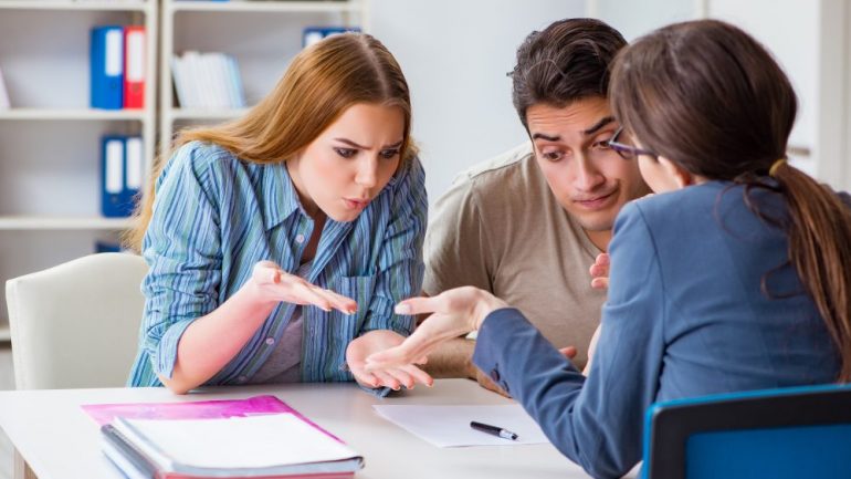 Young family disappointed by mortgage application denial at brokers office.