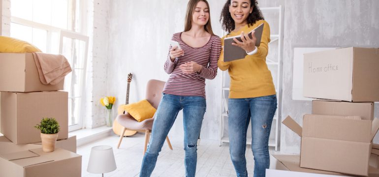 Cheerful young girls searching for lease to sublet an apartment from one to another.