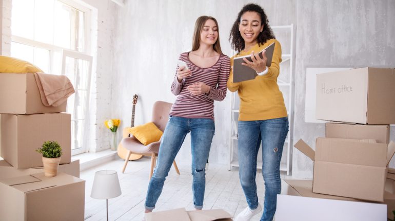 Cheerful young girls searching for lease to sublet an apartment from one to another.