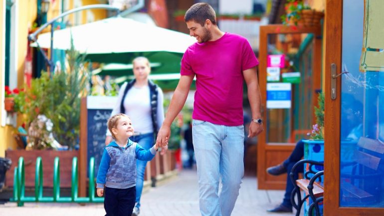 A happy father and son walking the city street settling into a new community.