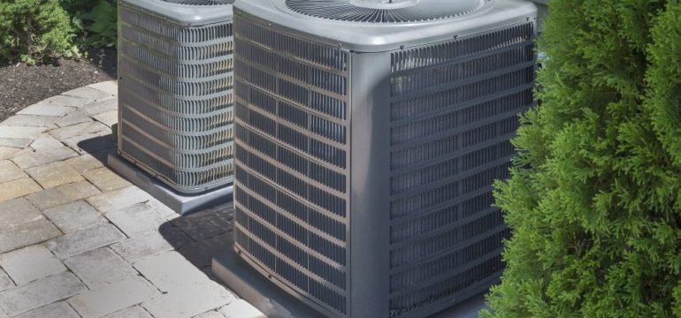 HVAC heating and air-conditioner units along side a home with screening landscape.