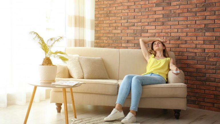 Woman suffering from heat due to temperature differences between the two levels of the home.