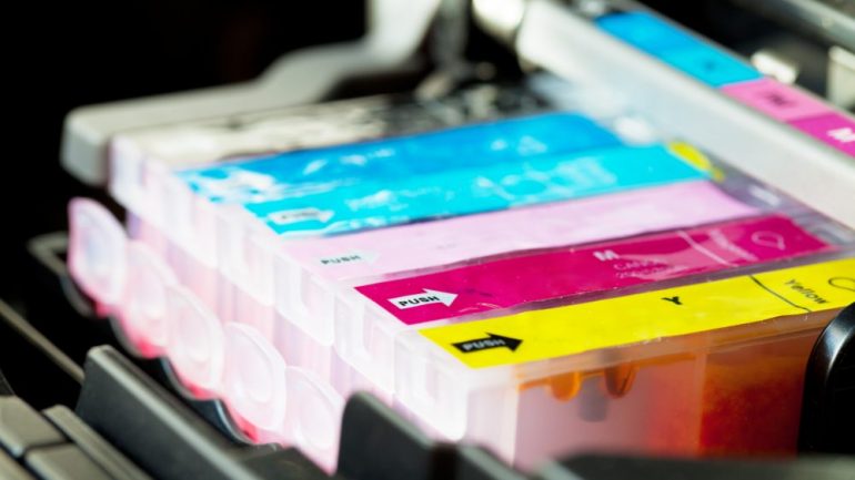 Color printer ink cartridges lined up in printer carriage.