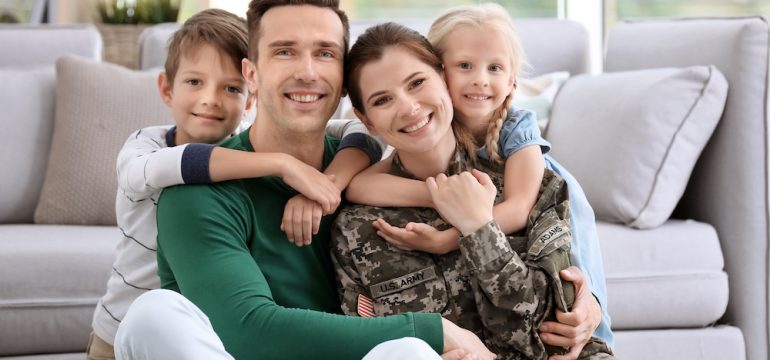 Veterans or active military represented by a woman in uniform with her family at home.