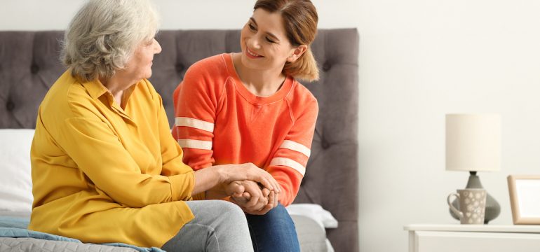 Elderly woman with female caregiver in bedroom of an accessible home.