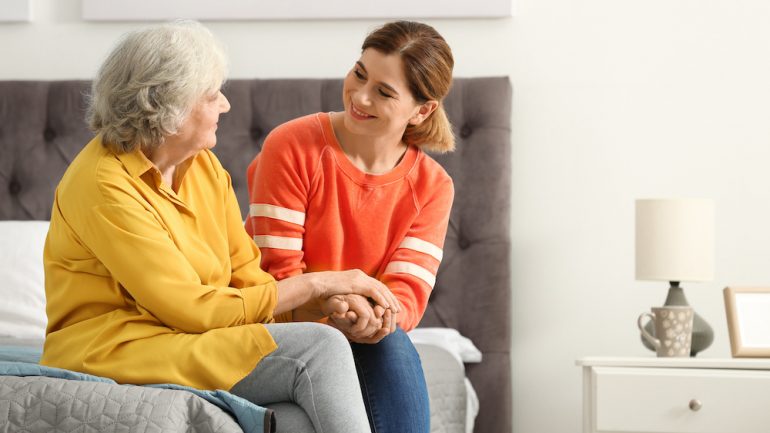 Elderly woman with female caregiver in bedroom of an accessible home.