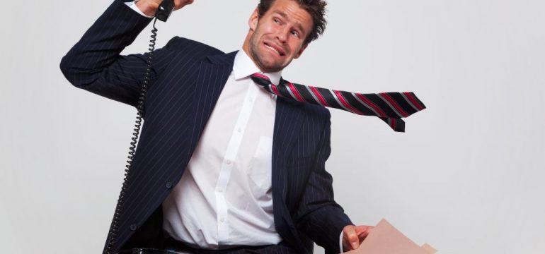Businessman getting a phone call from an angry customer shouting negative customer reviews through the line.