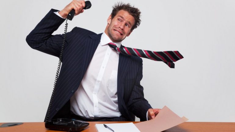 Businessman getting a phone call from an angry customer shouting negative customer reviews through the line.