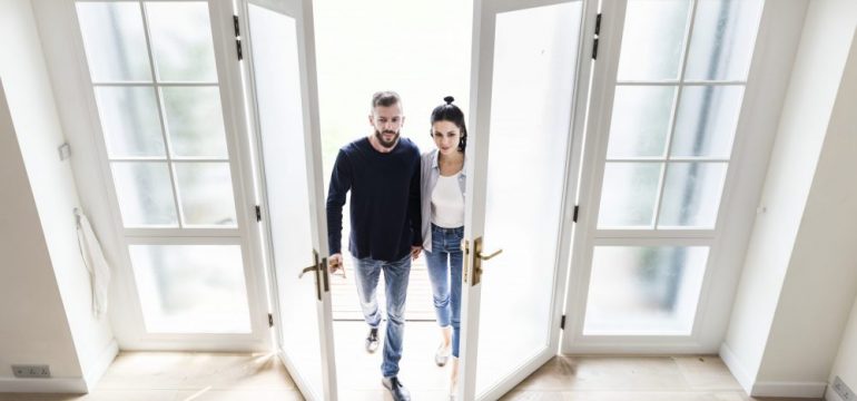 First-time home buyers entering the door of their new home.