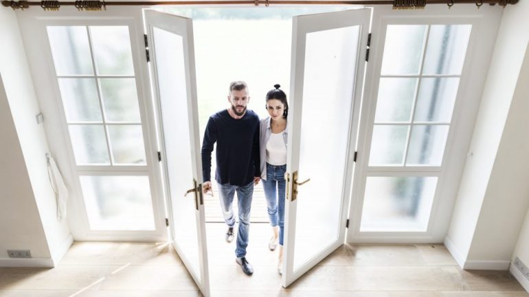 First-time home buyers entering the door of their new home.