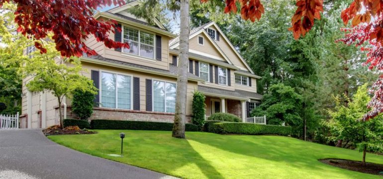 Beautiful large beige home on the hill surrounded by energy efficient landscaping.