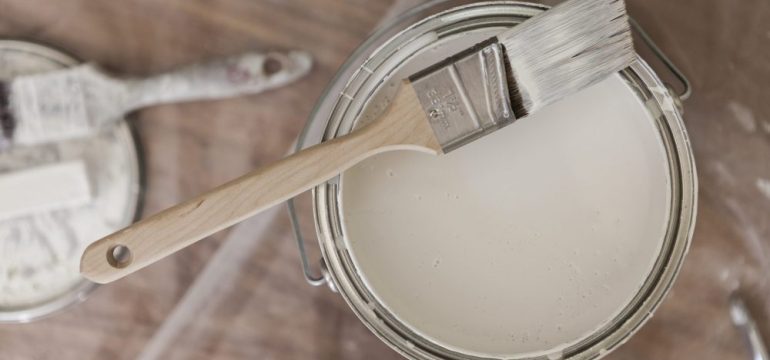 Paint brush resting on a low-VOC paint tin viewed from above.