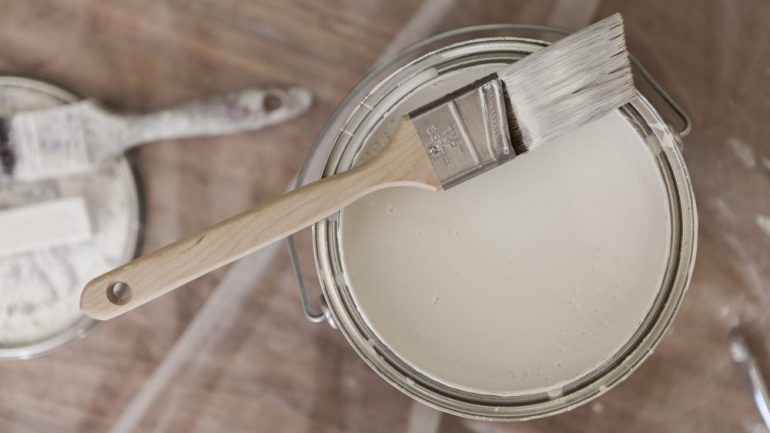 Paint brush resting on a low-VOC paint tin viewed from above.