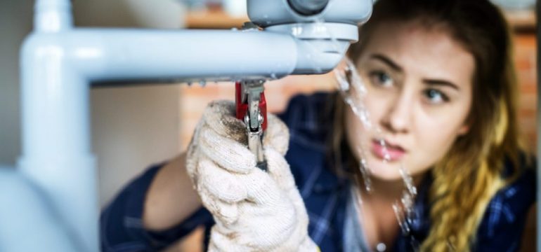 First-time homeowners fixing the kitchen sink.