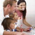 Family members brushing their teeth together in one bathroom in the home.
