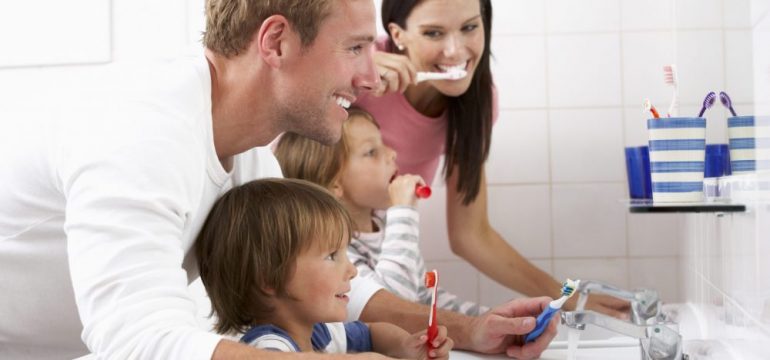 Family members brushing their teeth together in one bathroom in the home.