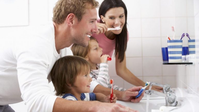Family members brushing their teeth together in one bathroom in the home.