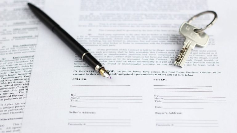 Sales contract for backup offer for real estate, with a gold-nibbed fountain pen and house keys.