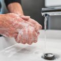 Coronavirus prevention showing hand washing with soap in hot water to prevent spread of virus in the home.