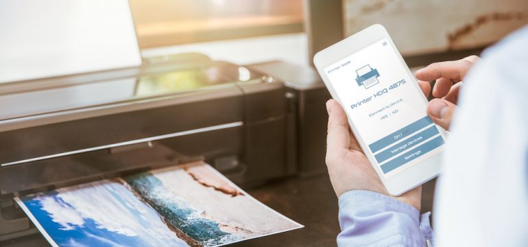 Man configures the connection of a mobile phone with a wireless printer.