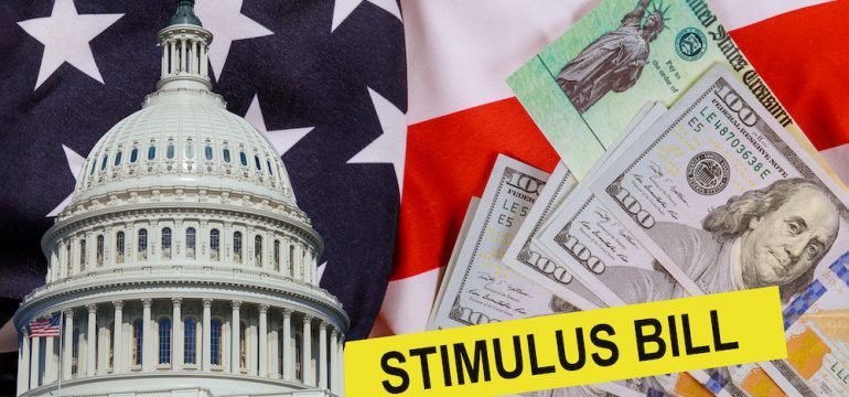 The CARES Act provides Coronavirus financial relief checks from the US government during the coronavirus crisis. Picture of US dollar, US Treasury check and US Capitol building cash on the American flag.