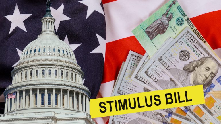 The CARES Act provides Coronavirus financial relief checks from the US government during the coronavirus crisis. Picture of US dollar, US Treasury check and US Capitol building cash on the American flag.