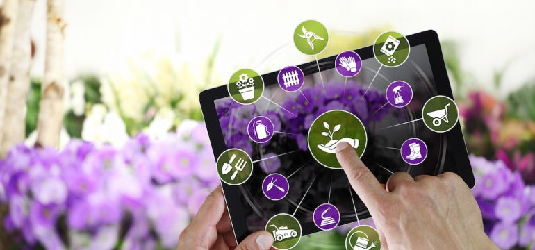 Buying plants online e-commerce concept on digital tablet, hand pointing and touch screen with tools icons, on spring flower plants background.