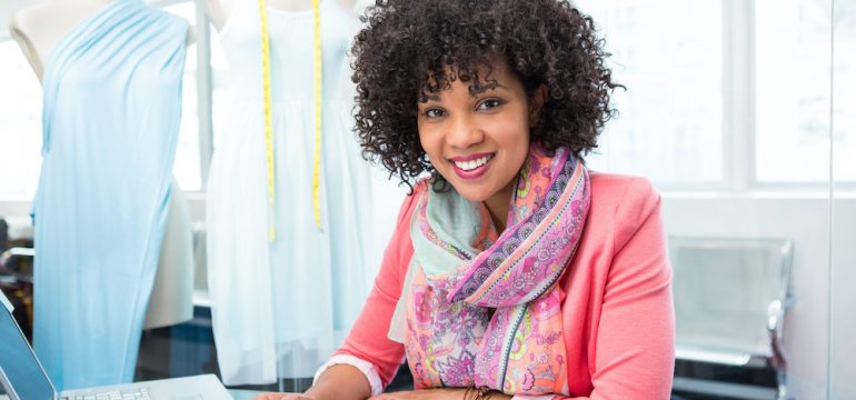 Attractive female, self-employed fashion designer at work applying for a bank statement loan on her laptop to buy a home.