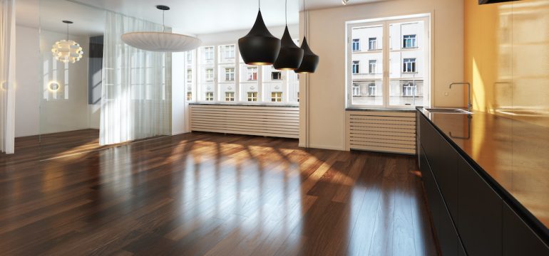 Empty living room area with gleaming hardwood floors.