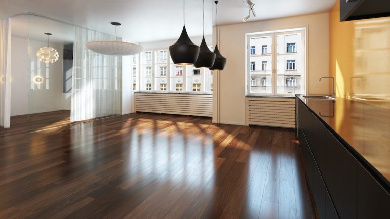 Empty living room area with gleaming hardwood floors.